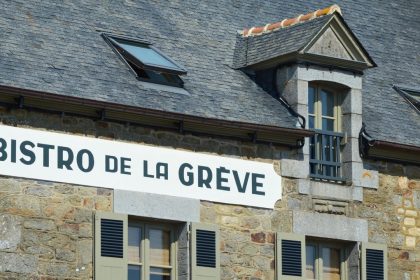 Fachada rústica de um bistrô de pedra com letreiro em francês, em Saint-Suliac, na Bretanha
