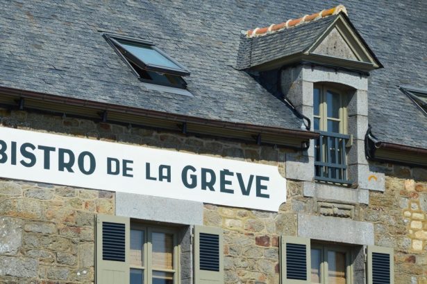 Fachada rústica de um bistrô de pedra com letreiro em francês, em Saint-Suliac, na Bretanha