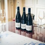 Garrafas e taças de vinho dispostas sobre uma mesa durante uma degustação em Beaune, na França