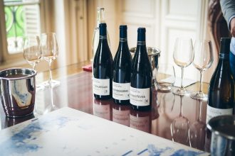 Garrafas e taças de vinho dispostas sobre uma mesa durante uma degustação em Beaune, na França