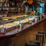Balcão de bar em Barcelona com uma variedade de tapas e pinchos espanhóis expostos.