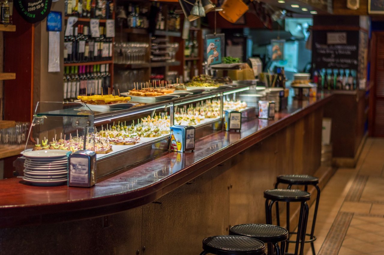 Balcão de bar em Barcelona com uma variedade de tapas e pinchos espanhóis expostos.