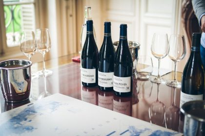 Garrafas e taças de vinho dispostas sobre uma mesa durante uma degustação em Beaune, na França