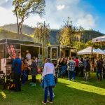 Mercado gastronômico ao ar livre, com barracas de comida e público circulando em Petrópolis, no Rio de Janeiro
