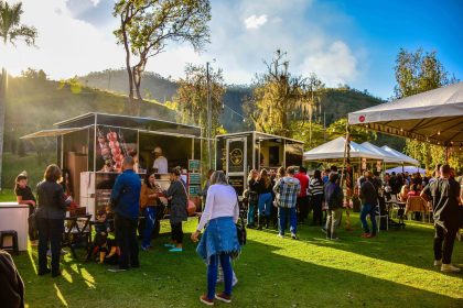 Mercado gastronômico ao ar livre, com barracas de comida e público circulando em Petrópolis, no Rio de Janeiro