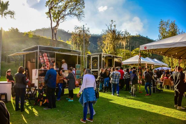 Mercado gastronômico ao ar livre, com barracas de comida e público circulando em Petrópolis, no Rio de Janeiro